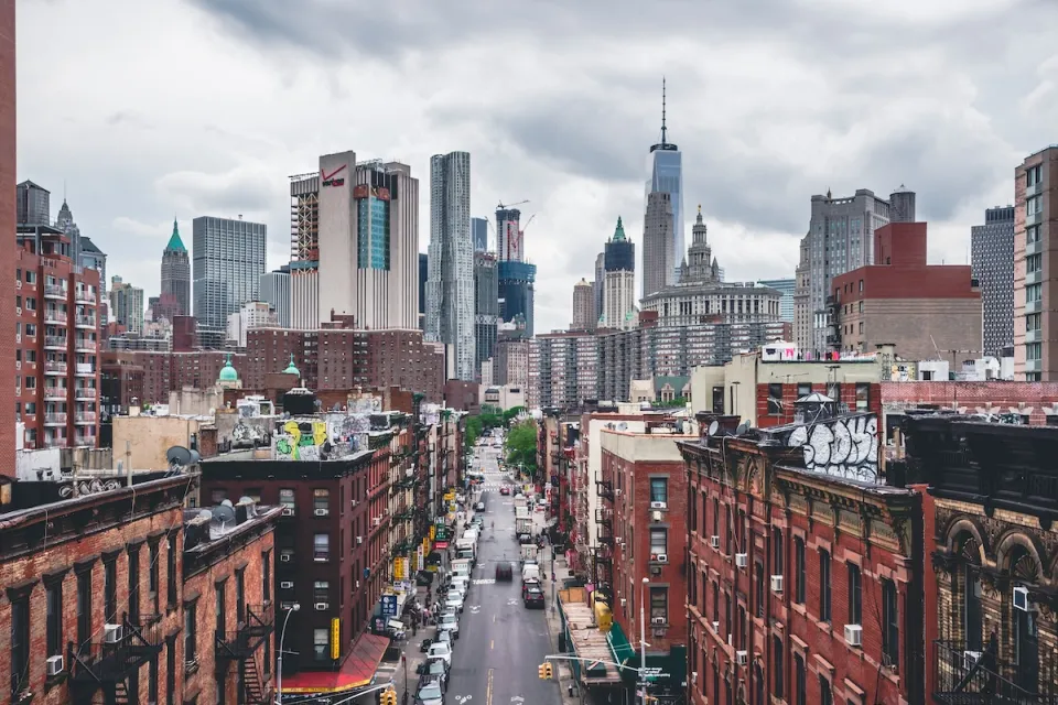 View of brick buildings and One World Trade Center building and New York City skyline.